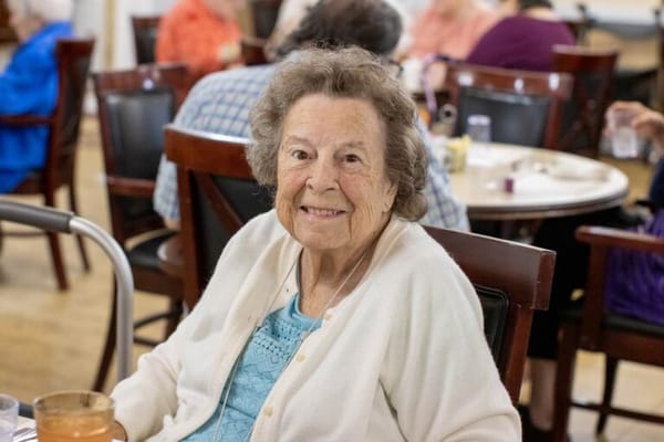 A smiling resident in a dining area