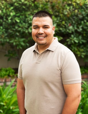 Staff member smiling in an outdoor garden area