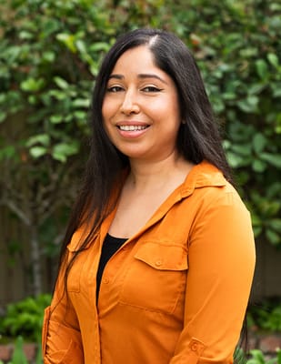 Staff member smiling in a garden area