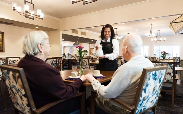 Staff serving coffee to residents in the dining room