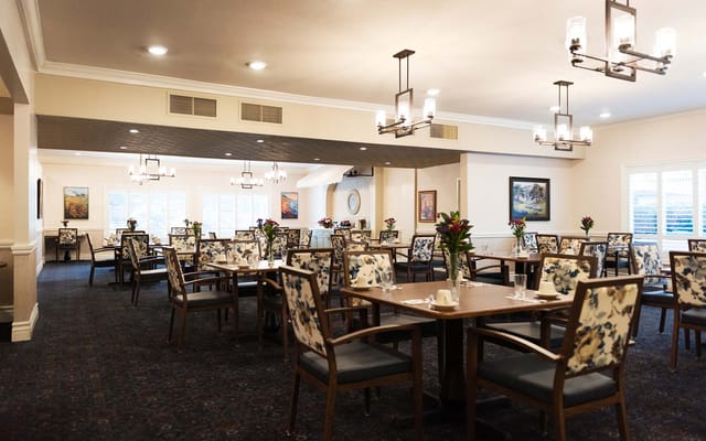 Bright dining room with floral decor and arranged tables