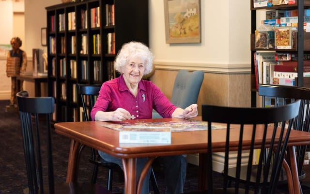 Resident enjoying a puzzle in the activity room