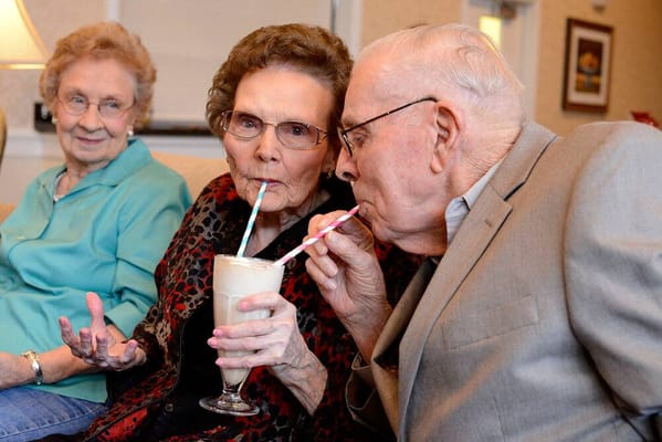 Seniors enjoying milkshakes during a social gathering