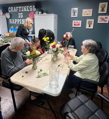Residents creating flower arrangements in an activity room