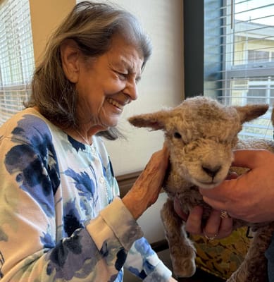 A resident enjoying interaction with a petting animal