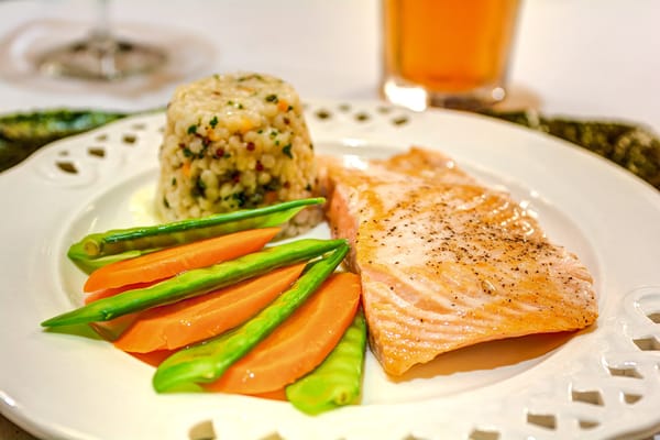 A plated meal with salmon, vegetables, and rice