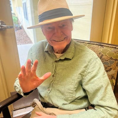 Resident waving in a cozy indoor setting