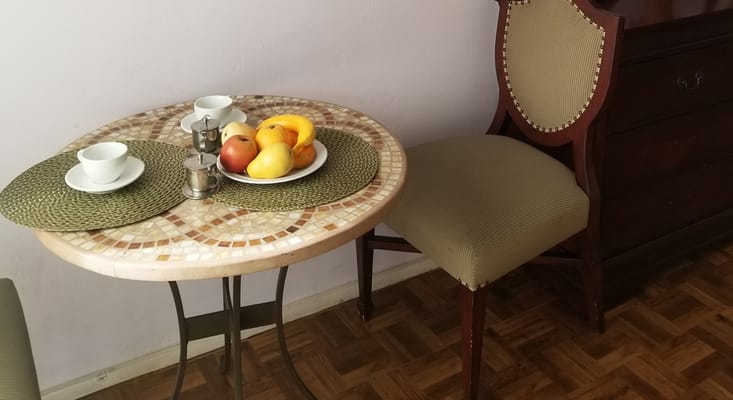 Table setting with fresh fruit and cups in a cozy dining area