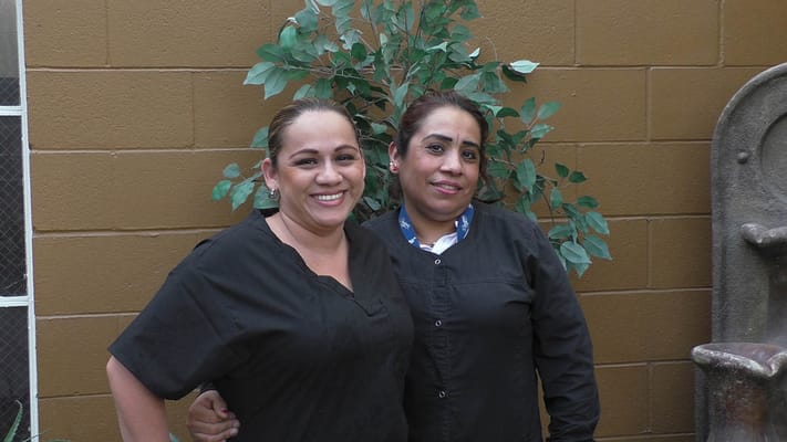 Two staff members smiling in a common area