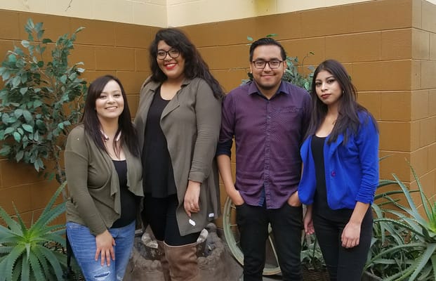 Staff posing in an outdoor area with plants