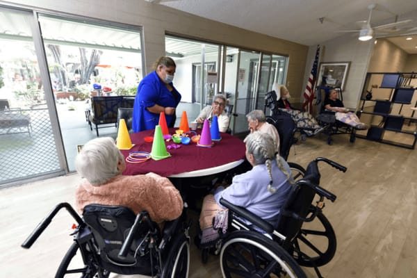 Residents participating in an activity with staff in a common area