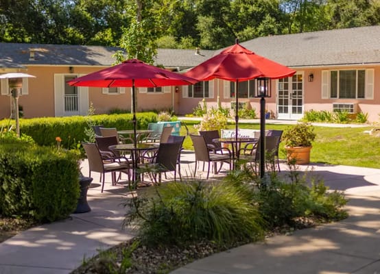 Outdoor seating area with red umbrellas and tables