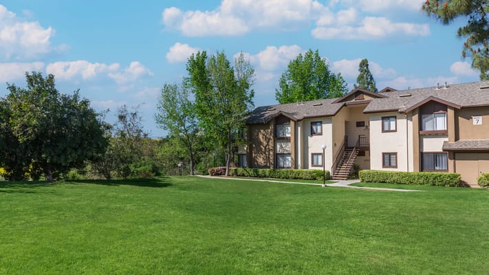 Exterior view of a senior living facility with green lawn