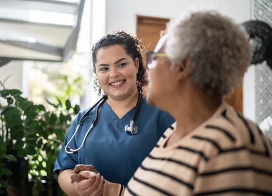 Nurse interacting with a resident in a bright indoor space