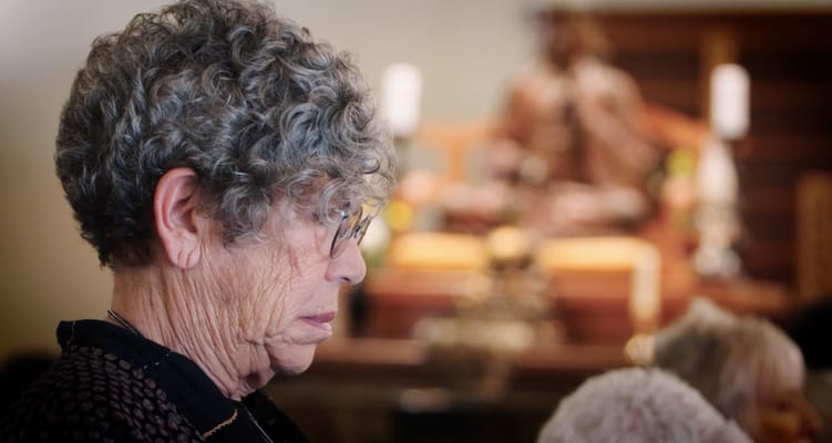 A woman with curly hair in a thoughtful moment in an indoor setting