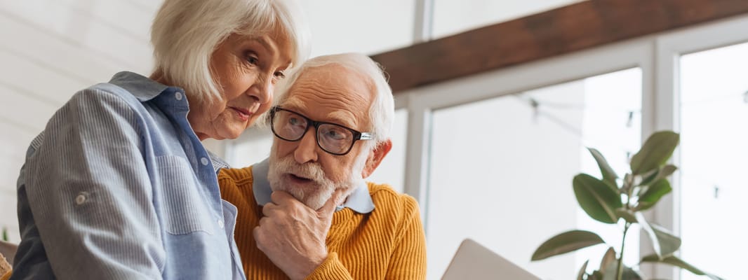 Two seniors engaging in conversation indoors