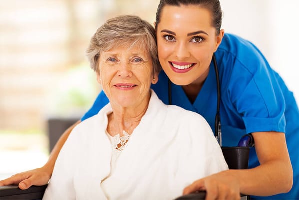 A caregiver smiling with a senior resident