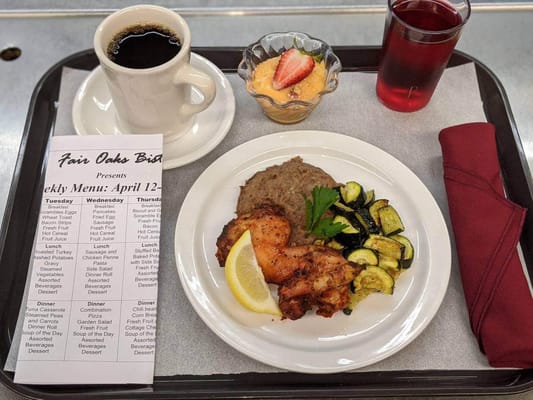 A dining tray with a meal, coffee, and dessert