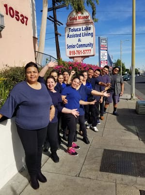 Staff members outside Fine Gold Manor smiling together