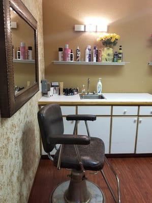 Interior of a hair salon with a barber chair and products