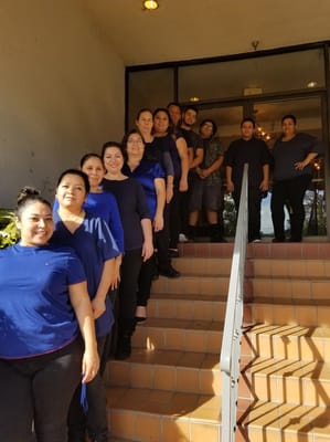 Staff members posing in front of the facility entrance