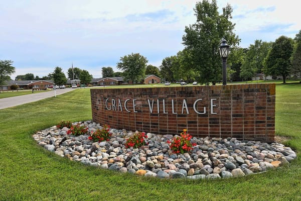 Signage for Grace Village in a landscaped area