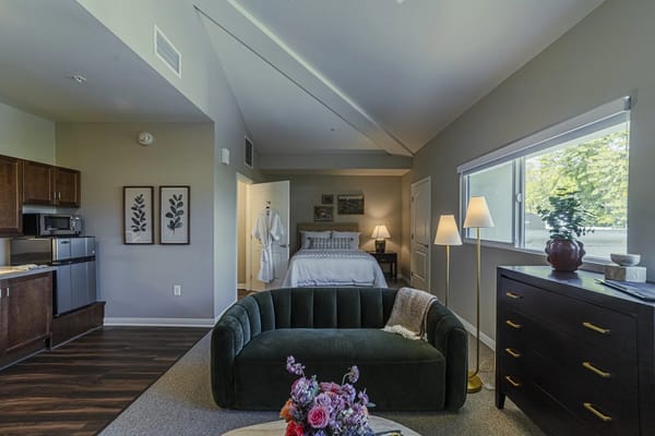 Well-furnished resident room with seating and plants