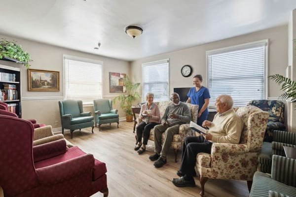 Residents and staff interacting in a cozy living room