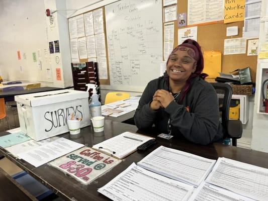 Staff member at reception area with survey box