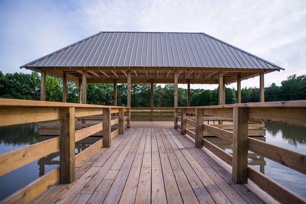 A wooden deck leading to a gazebo by the water