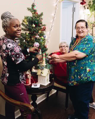 Staff and residents decorating a Christmas tree together