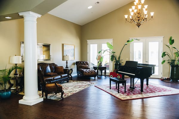 Bright interior common area with a piano and seating