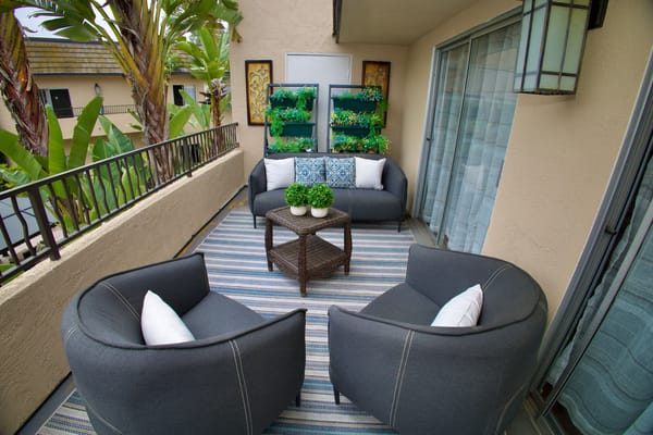 Outdoor seating area with plants and comfortable chairs