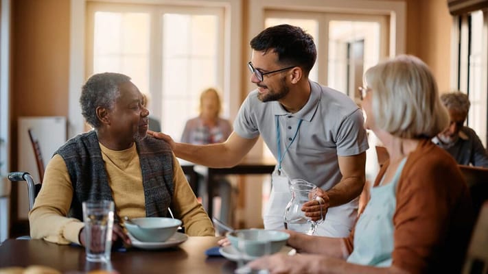 Care staff interacting with residents in a dining area