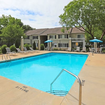 Outdoor pool area with lounge chairs and umbrellas
