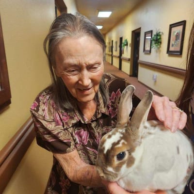 Resident interacting with a rabbit in a hallway
