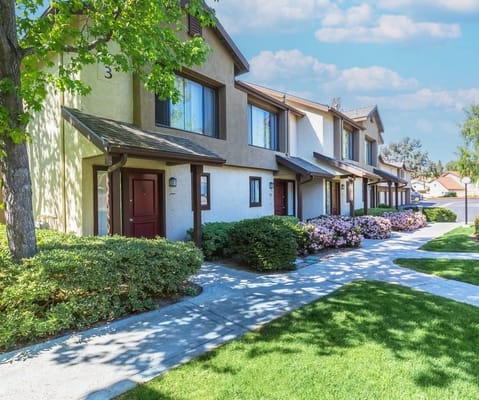 Exterior view of a senior living building with walkways and flowers