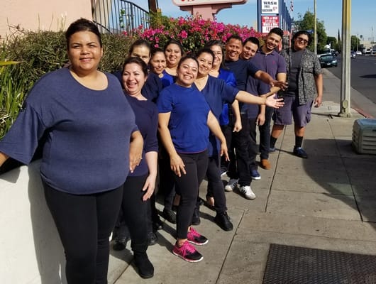 Staff members posing happily outside.