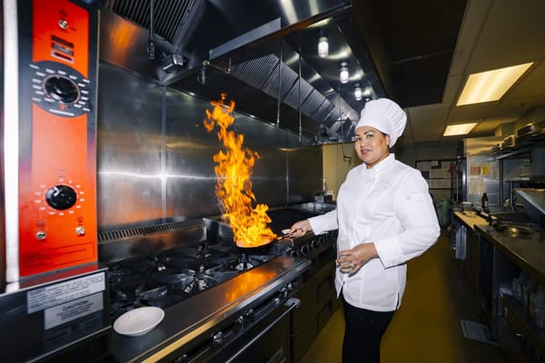 Chef cooking in a commercial kitchen with flames