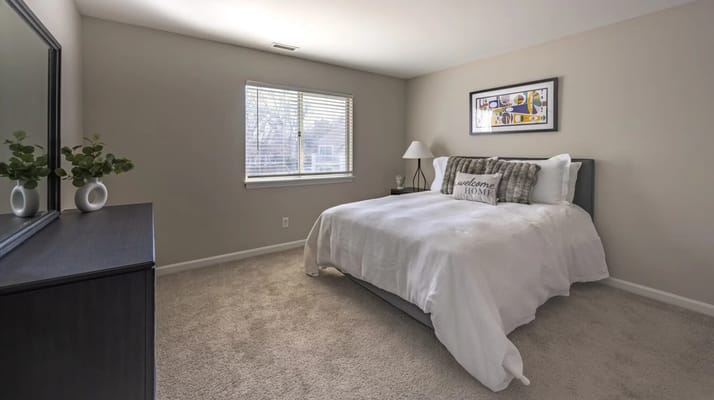 A bright resident room with a cozy bed and window