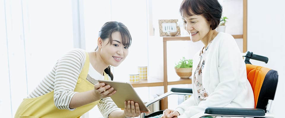 Caregiver assisting a resident in a bright common area