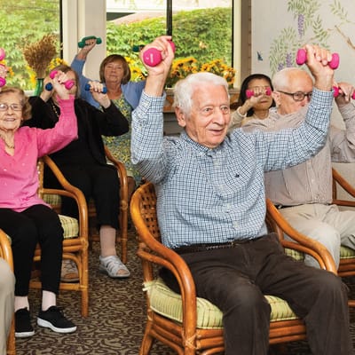 Residents participating in a group exercise activity indoors