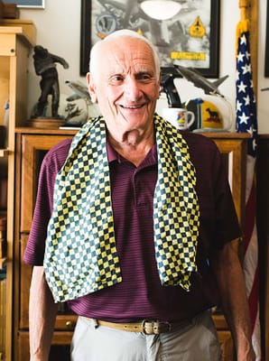 Smiling resident wearing a patterned scarf in an interior setting