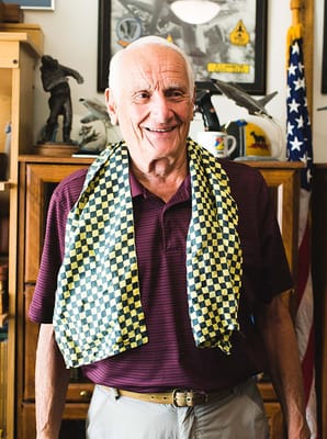 Smiling resident wearing a patterned scarf in an interior setting