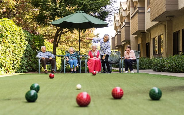 Residents enjoying outdoor lawn games in a green area