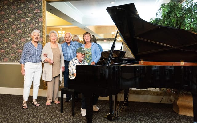 Residents enjoying piano music during an activity