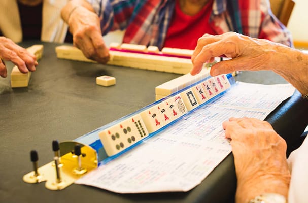 Residents playing mahjong with visible hands