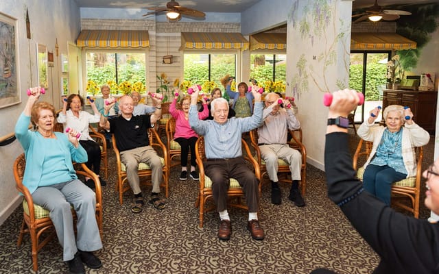 Residents participating in a group exercise class with weights