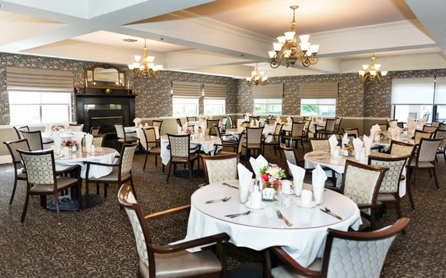 Dining room set up for a meal with tables and chairs