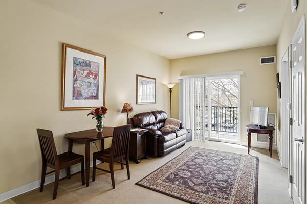Cozy resident room with furniture and balcony access